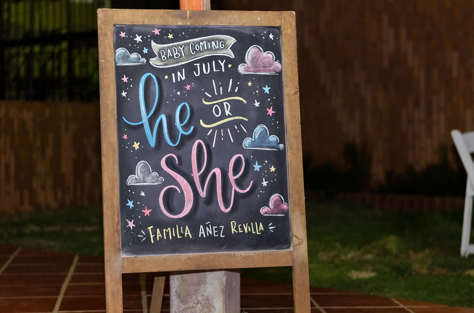 A colorful Gender Reveal Sign that reads "Baby coming in July: He or She?"
